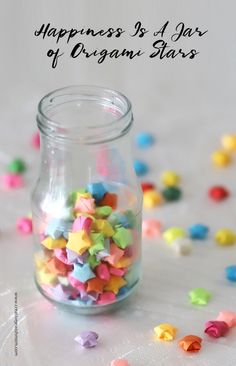 a jar filled with colorful stars sitting on top of a table