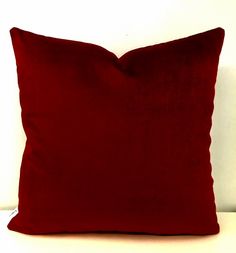 a red pillow sitting on top of a white couch