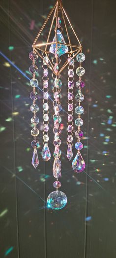 a wind chime hanging from the ceiling in front of a window with colorful lights