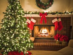 two christmas stockings hung over a fireplace in front of a decorated christmas tree and fire place