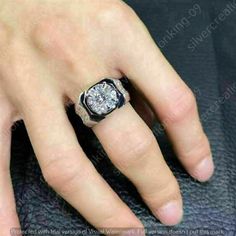 a man's hand with a diamond ring on top of his finger and the other hand in front of him