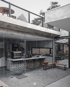 an outdoor kitchen with tables and benches on the side of it, surrounded by glass walls