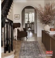 a living room filled with furniture next to a staircase