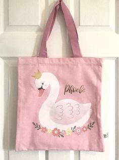 This pink tote bag features a sweet swan design and the custom name of your choice in reflective gold lettering. Perfect size for little-ones' bits and bobs as well as for shopping, or as a bag for school, PE, or ballet class.  To personalise: Please write the name you would like to appear on the bag in the personalisation field (up to 9 characters).  Sending directly to your recipient? Need a gift note? Remember to write your gift message in the gift note section at checkout. Gift wrap options are also available.  Personalised bags take 1- 3 working days to complete before being dispatched and are sent via Royal Mail. Postal upgrades are available at checkout.  Care instructions: We recommend you only gently wipe clean to give your bag the longest life possible  This is a Sass & Belle bag Cute Gold Bags For Everyday Use, Cute Gold Bag, Pink Canvas School Bag, Personalized Pink Bag For Mother's Day, Pink Tote Bag For Mother's Day, Personalized Pink Bag For Everyday, Personalized Pink Bags For Everyday, Pink Canvas Gift Bag, Pink Rectangular Bag For Personalized Gift