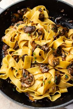 a skillet filled with pasta and mushrooms