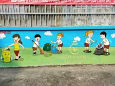 a mural on the side of a building depicts children playing with trash cans and garbage cans