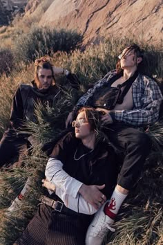 three people laying in the grass with their eyes closed