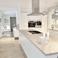 a modern kitchen with white cabinets and stainless steel appliances, including an island countertop