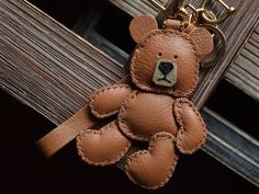 a brown teddy bear keychain sitting on top of a wooden door