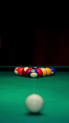 a pool table with several billiards on it and a ball in the foreground