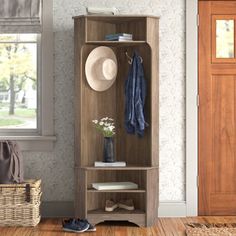 a hat and coat rack in the corner of a room next to a basket with shoes on it