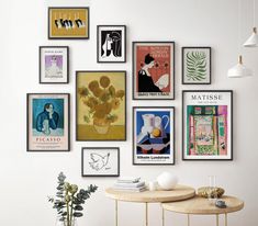 there are many framed art on the wall in this living room, including posters and vases