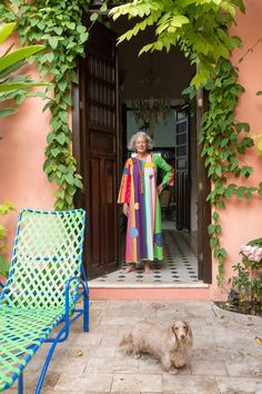 a woman standing in front of a doorway next to a dog