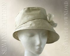 a white mannequin head wearing a beige hat with a bow on the brim