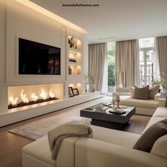 a living room with white furniture and a flat screen tv mounted on the wall above it