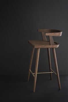 a wooden stool sitting on top of a black floor