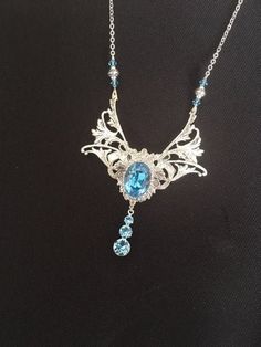 Superb art nouveau silver and sky blue necklace with Swarovski crystal: the necklace consists of an art nouveau print, silver-plated brass, attached to two volutes of art nouveau acanthus leaves, silver-plated brass. In the center is attached a sky blue Swarovski crystal cabochon, inserted in a silver setting. CABOCHON'S COULEUR CAN BE MODIFIED ON DEMANDE (violet, green, red, etc.) Just contact me by email to find out the available colors or the time to supply (usually 2 to 3 days). Beneath the Sky Blue Necklace, Elf Necklace, Art Nouveau Silver, Necklace Art, Acanthus Leaf, Fantasy Jewelry, Blue Necklace, Blue Art, Jewelry Tutorials