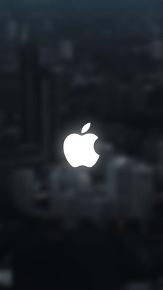 an apple logo is shown on the side of a building in front of city lights