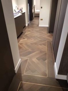 an empty hallway with wood flooring and white walls in a home or business setting