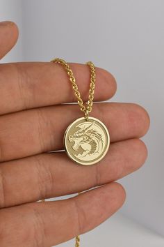 ▪️ A beautiful dragon pendant made out of 14K Real Gold. Available only in yellow gold! ▪️ Pendant Thickness: 0.60mm ▪️ Pendant Dimensions: - 20mm / 0.78 inches - 22mm / 0.86 inches - 24mm / 0.94 inches ▪️ Rope Chain Thickness: 2.10mm Welcome to RedGiftBox, it is our pleasure providing you our fine gold jewelry! Style 3(Rope Chain): - 14K Real Gold - 2.10mm Thickness - Spring Ring Clasp Weight per length: 40CM / 15.7 Inches - 2.05 grams 45CM / 17.7 Inches - 2.26 grams 50CM / 19.7 Inches - 2.47 g Symbolic Gold Dragon Jewelry, Symbolic Gold Jewelry With Dragon Design, Yellow Gold Dragon Pendant Jewelry, Gold Dragon Design Jewelry, Gold Jewelry With Dragon Design, Yellow Gold Dragon Design Pendant Jewelry, Round Dragon Design Jewelry For Gifts, Gold Round Jewelry With Dragon Design, Dragon Design Jewelry For Gift