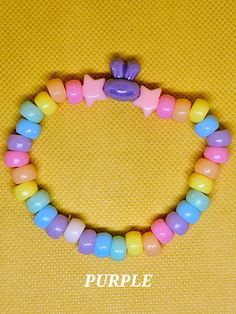 ""Kawaii" is a word that describes a style of art, design, and behavior that conveys cuteness, innocence, and joy." (Merriam-Webster). This Bunny Kandi Bracelet bracelet exemplifies what kawaii is with its adorable bunny beads and pastel colors.  This handmade bracelet is 18cm. (7in.) in length and is made with plastic and acrylic beads. The pony beads seen are the standard 5mm size, whereas the bunny and star beads are 10mm and 8mm respectively. The whole piece is tied together with a stretchy, yet durable, elastic cord. The bracelet is lightweight and is comfortable to wear.  This kandi bracelet is suitable for any ocassion and would be a great gift for anyone who is into a more kawaii aesthetic or kawaiicore fashion. Anyone can wear this piece regardless of age, gender, or orientation. Cute Plastic Stretch Bracelet As Gift, Pink Adjustable Bracelet For Playtime, Cute Plastic Stretch Bracelet Gift, Adjustable Pink Bracelets For Playtime, Adjustable Pink Bracelet For Playtime, Adjustable Cute Kawaii Jewelry, Adjustable Kawaii Beaded Bracelet For Birthday, Adjustable Kawaii Jewelry With Cute Design, Adjustable Kawaii Bracelets With Round Beads