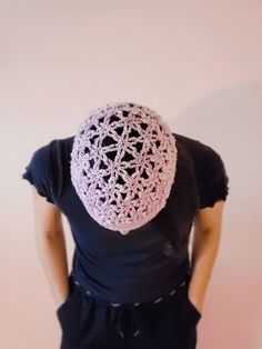 a woman is wearing a crocheted hat in front of her head and back