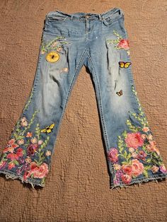 a pair of jeans with flowers and butterflies on them