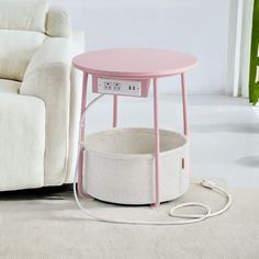 a pink table sitting on top of a rug next to a white couch and chair