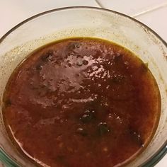 a glass bowl filled with sauce on top of a counter