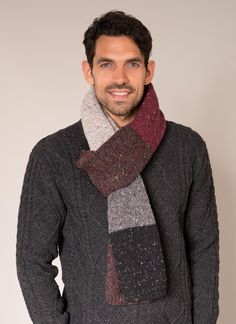 a man wearing a gray sweater and a red, black, grey and white scarf