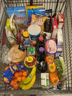 a shopping cart filled with lots of food and condiments on top of it