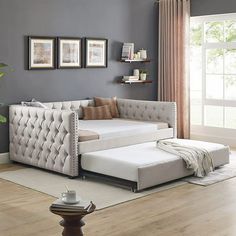 a living room with gray walls and white furniture in the corner, including a large sectional couch