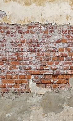 an old brick wall with peeling paint on it