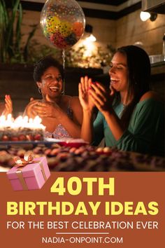 two women sitting at a table in front of a birthday cake