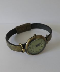 This is a round watch for women. The case is aged bronze appearance alloy, free of nickel and lead, 1.25 inches diameter. The clasp is magnetic. The strap is made in bronze color leather. The strap comes in 6 measures: XS (for a 6.00 inches wrist), S (for a 6.25 inches wrist), M (for a 6.50 inches wrist), L (for a 6.75 inches wrist), XL (for a 7.00 inches wrist), XXL (for a 7.25 inches wrist). If you need a different size, please send me a message. NOTE: You can measure your wrist (no to tight, Vintage Adjustable Metal Watch Accessories, Brown Adjustable Watch Accessories With Metal Dial, Brown Watch Accessories With Metal Dial And Adjustable Fit, Unusual Watches, Simple Watches, Casual Rings, Round Watch, Minimalist Watch, Aged Bronze