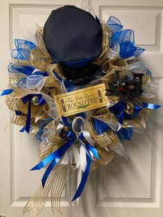 a blue and gold wreath with a hat on it