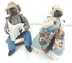 two stuffed animals sitting next to each other on top of a white table with a book in front of them