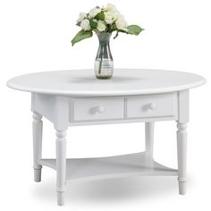 a white coffee table with drawers and a vase filled with flowers on the top shelf