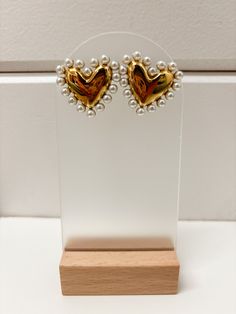 Enhance your outfit with our {CP} Pearl Heart Earrings. These elegant earrings feature a stunning pearl detail and are designed to be lightweight for comfortable wear. 18k Gold Plated Stainless Steel. Heart-shaped Pearl Party Earrings, Heart-shaped Pearl Earrings For Valentine's Day, Trendy Gold Pearl Earrings, Gold Pearl Earrings For Valentine's Day, Valentine's Day Pearl Party Earrings, Valentine's Day Party Pearl Earrings, Heart-shaped Pearl Earrings For Valentine's Day Anniversary, Heart-shaped Pearl Earrings For Anniversary On Valentine's Day, Gold Pearl Earrings For Anniversary On Valentine's Day