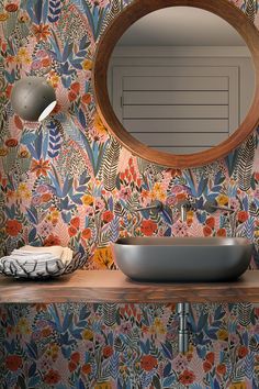 a bathroom sink sitting under a round mirror next to a wall mounted faucet