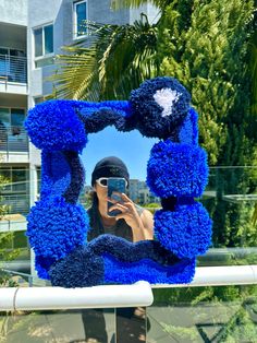 a person taking a selfie in front of a mirror with blue decorations on it