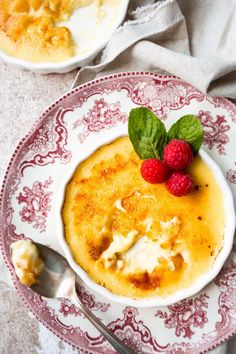 two bowls of food with raspberries on top