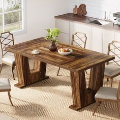 a wooden table with chairs around it and a bowl of fruit on the dining room table