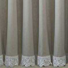 the curtains are lined up with white lace