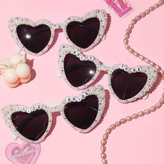 three pairs of heart shaped sunglasses with pearls on them