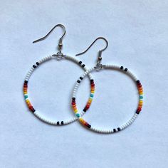 These handmade, beaded hoop, earrings come in a variety of colors. This is a gorgeous white sunset pattern. Perfect for all occasions and super comfortable to wear. These earrings are not heavy at all and can be worn comfortably all day. The earrings are 5 cm across. Every pair is unique and  may look somewhat different than the picture. I love making these earrings and hope you enjoy wearing them! Small Hoop Beaded Jewelry For Beach, Bohemian White Beaded Hoop Earrings, Bohemian White Hoop Earrings For Beach, Bohemian Heishi Beads Hoop Earrings, Bohemian Heishi Beads Small Hoop Earrings, Hoop Beaded Earrings With Dangling Beads For Beach, Beaded Small Hoop Earrings For Beach, Handmade Hoop Beaded Earrings For Beach, Handmade Beaded Hoop Earrings For Beach