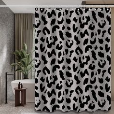 a shower curtain with black and white animal print on the side, in a bathroom