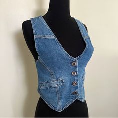 You'll Feel On-Trend Wearing This Women's Denim Vest By A.N.A As A Layering Piece. Crafted From A Structured Recycled Denim Blend With A Hint Of Stretch, This Sleeveless Cropped Vest Has A Button-Front Closure And Side Slip Pockets. Wear It On Its Own With Wide-Leg Pants Or Jeans Or Over A Fitted Baby Tee. Strap Type: Adjustable Closure Type: Button Fit: Regular Fit Neckline: V Neck Pockets: 2 Front Slip Pockets Sleeve Length: Sleeveless Apparel Length: 20 Inches - Front Fiber Content: 94% Cotto Fitted Medium Wash Recycled Denim Jacket, Fitted Blue Cotton Denim Vest, Trendy Fitted Blue Denim Vest, Trendy Fitted Washed Blue Denim Vest, Fitted Dark Wash Denim Top, Fitted Dark Wash Denim Top Casual Style, Fitted Casual Dark Wash Denim Top, Casual Fitted Dark Wash Denim Top, Fitted Denim Jacket In Recycled Denim