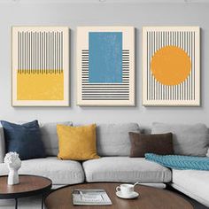 three paintings on the wall above a couch in a living room with a coffee table