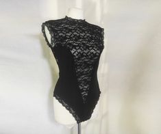 Seductive lace bodysuit with a plunging V and sheer design from 80s-90s. The back is entirely sheer, with a delicate lace design, and features a button loop deep keyhole closure for an added touch of elegance. The bodysuit fastens securely with a hook and eye closure, ensuring a comfortable and snug fit. The scalloped edges around the band collar, armpits, and legs add a touch of vintage charm, while the stretchy fabric ensures it fits perfectly * excellent vintage condition there is a tiny defe Style Collage, Corset Bodysuit, Vintage Goth, Lace Corset, Womens Bodysuit, Band Collar, Scalloped Edges, Lace Bodysuit, Lace Design